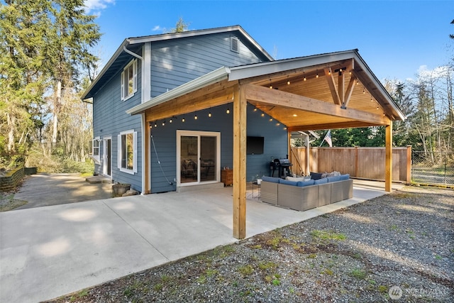 rear view of house with a patio, fence, and an outdoor hangout area