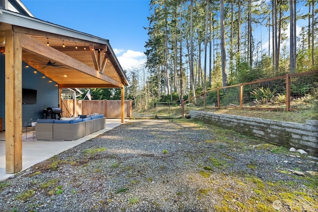 view of yard with an outdoor living space, a patio, a ceiling fan, and fence