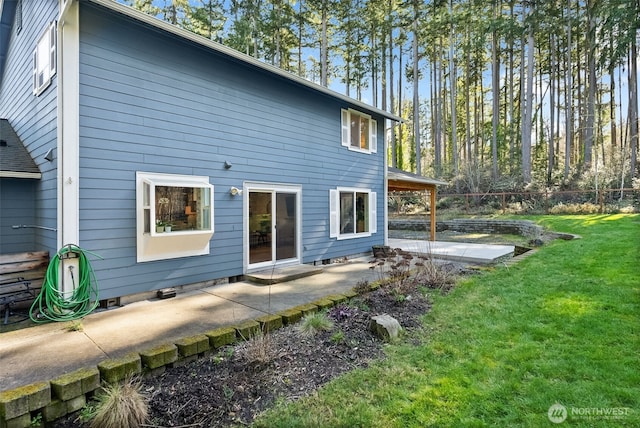 rear view of property featuring a yard and a patio