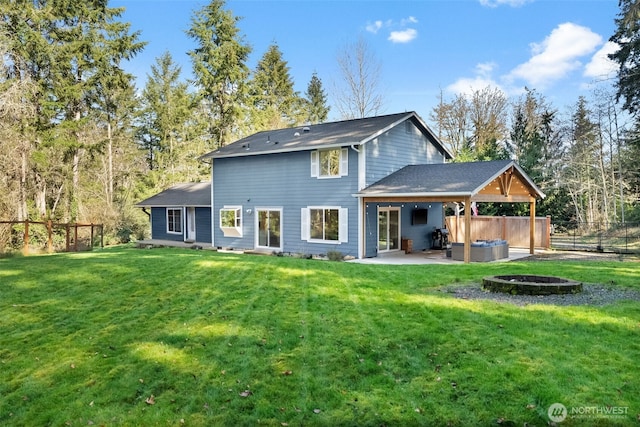 rear view of house featuring a lawn, a patio area, fence, and a fire pit