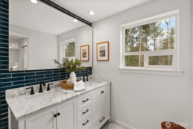 full bath with a sink, tasteful backsplash, recessed lighting, and double vanity