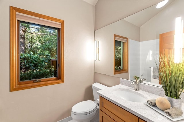 bathroom featuring lofted ceiling, toilet, and vanity