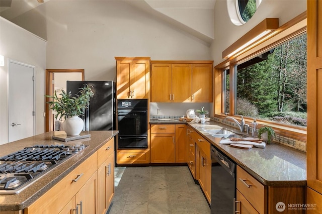 kitchen featuring stainless steel gas cooktop, dishwasher, freestanding refrigerator, a warming drawer, and a sink