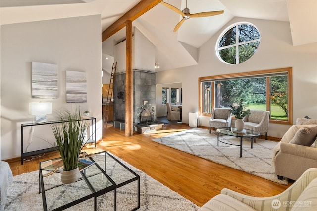 living room featuring ceiling fan, baseboards, high vaulted ceiling, and wood finished floors