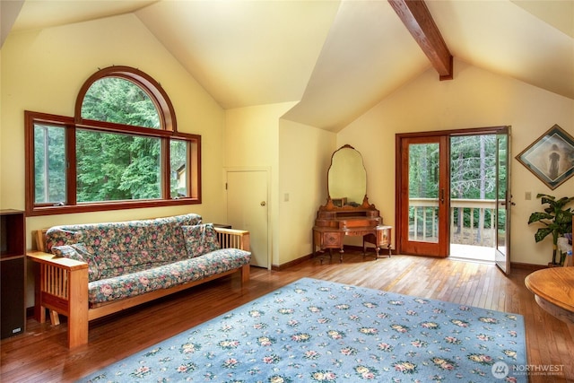 sitting room featuring lofted ceiling with beams, baseboards, and wood-type flooring