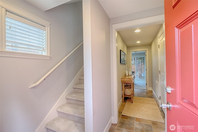 staircase featuring recessed lighting, stone finish floor, and baseboards