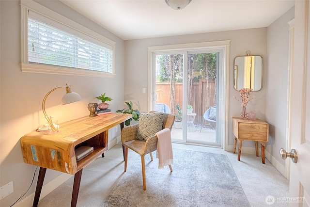 office space with baseboards and light carpet