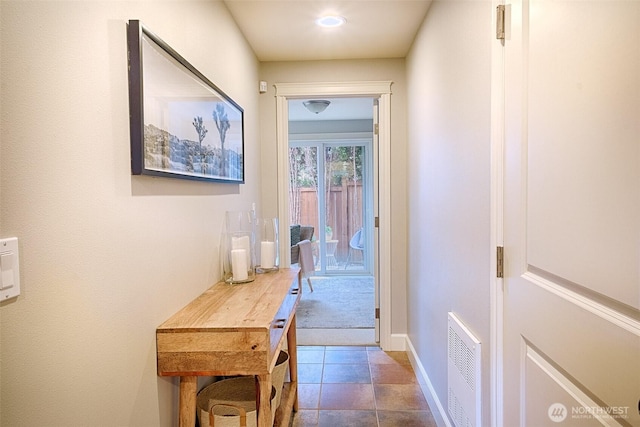 hallway featuring visible vents and baseboards