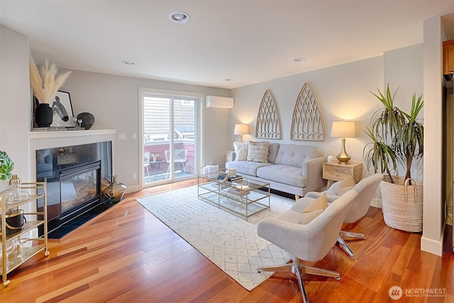 living room with recessed lighting, baseboards, wood finished floors, and a wall unit AC