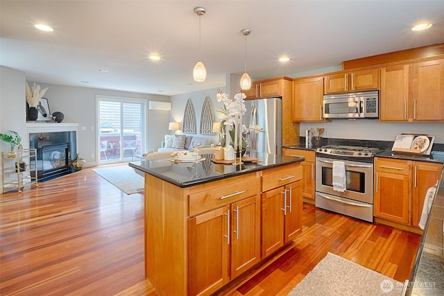 kitchen with open floor plan, recessed lighting, stainless steel appliances, and wood finished floors