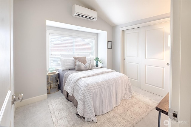 bedroom with lofted ceiling, an AC wall unit, a closet, carpet floors, and baseboards