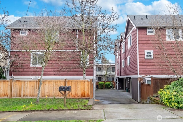 view of property exterior with driveway and fence