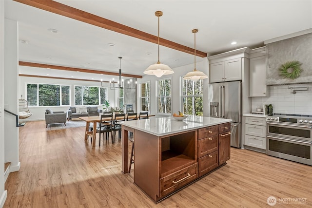 kitchen with light wood finished floors, open floor plan, beamed ceiling, decorative backsplash, and appliances with stainless steel finishes