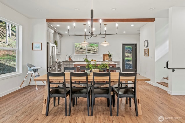 dining area featuring light wood-type flooring, baseboards, a healthy amount of sunlight, and stairs