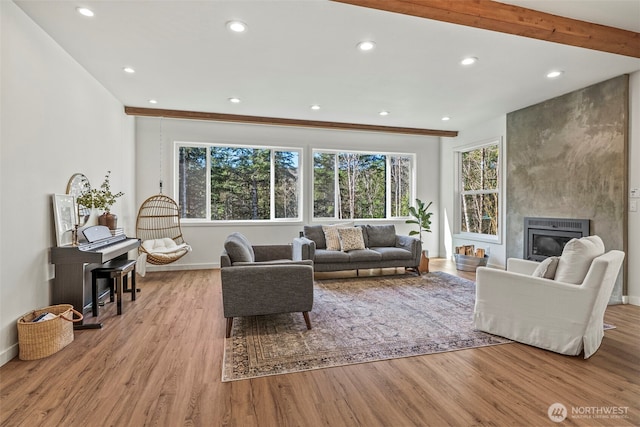 living area featuring beam ceiling, wood finished floors, recessed lighting, a fireplace, and baseboards