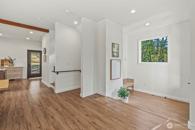 interior space with beamed ceiling, recessed lighting, wood finished floors, and baseboards