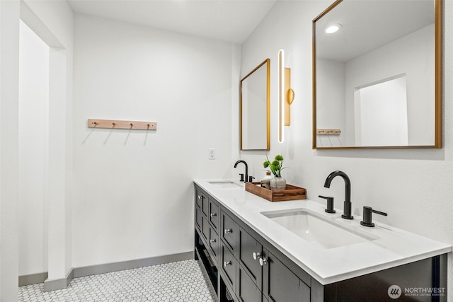 full bathroom with double vanity, recessed lighting, baseboards, and a sink