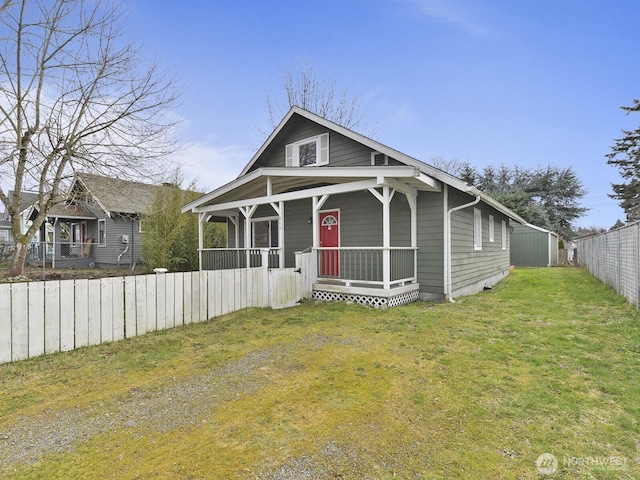 view of front of house with a porch, a front yard, and fence