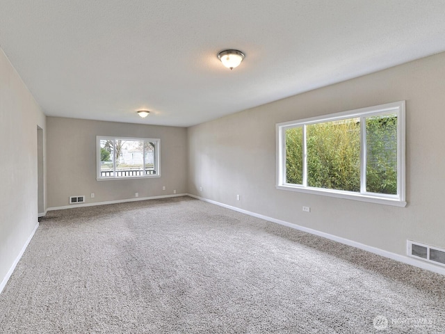 carpeted empty room with baseboards and visible vents