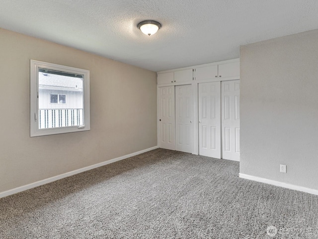 unfurnished bedroom featuring baseboards, a closet, a textured ceiling, and carpet