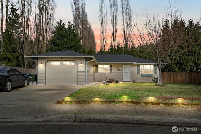 single story home featuring a lawn, an attached garage, driveway, and fence