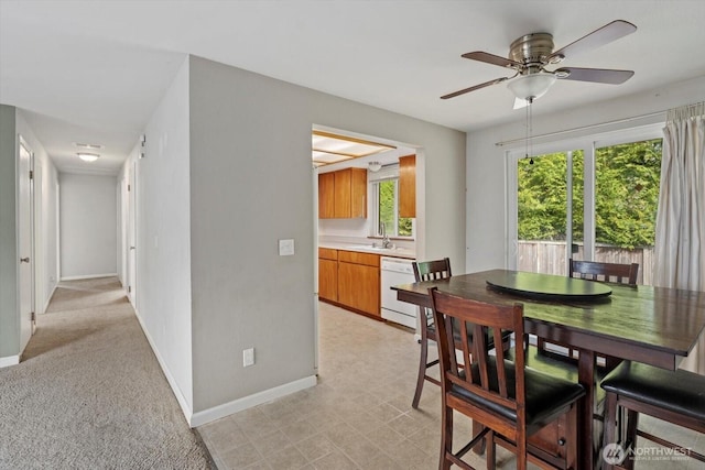 dining room with a ceiling fan and baseboards