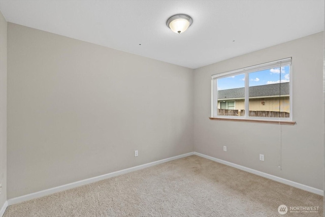 spare room featuring carpet and baseboards