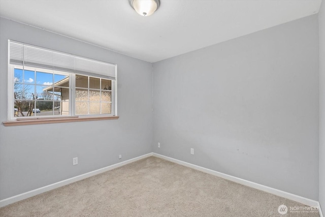 spare room featuring baseboards and carpet flooring