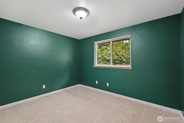 carpeted empty room with baseboards