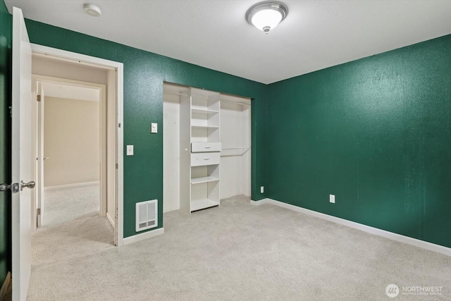 unfurnished bedroom with a closet, baseboards, visible vents, and carpet floors