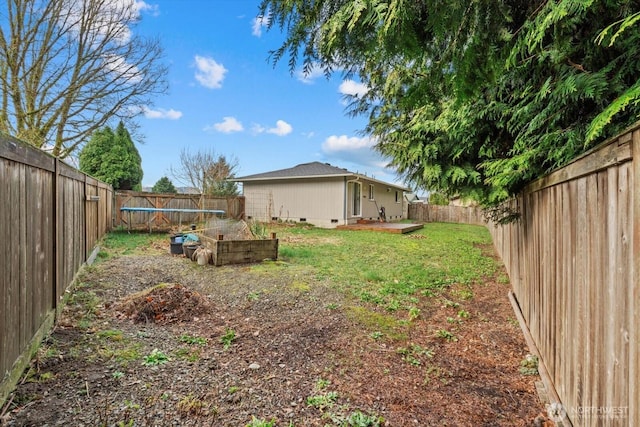 view of yard featuring a trampoline and a fenced backyard