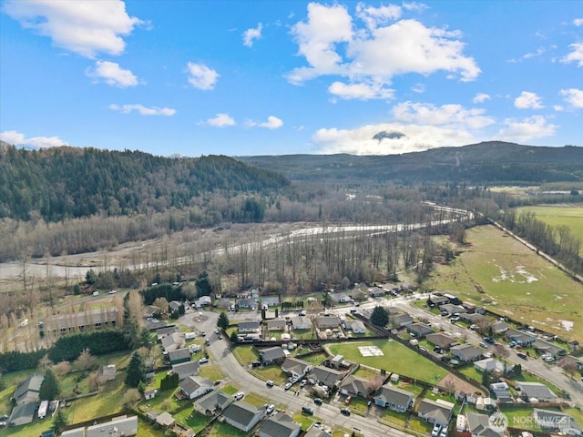 aerial view featuring a wooded view, a mountain view, and a residential view