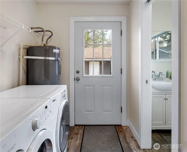 laundry area featuring a sink, a healthy amount of sunlight, water heater, and washing machine and clothes dryer