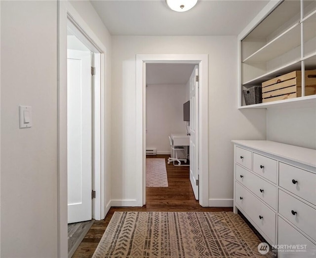 hall featuring baseboards, dark wood-type flooring, and baseboard heating