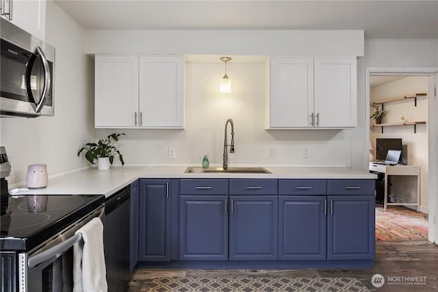 kitchen featuring white cabinets, blue cabinets, appliances with stainless steel finishes, and a sink