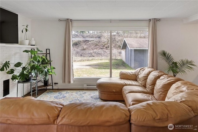 living area with a baseboard heating unit and a fireplace