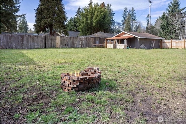 view of yard with a fenced backyard and an outdoor fire pit