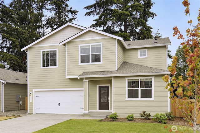 traditional-style house featuring a garage, a shingled roof, driveway, and fence