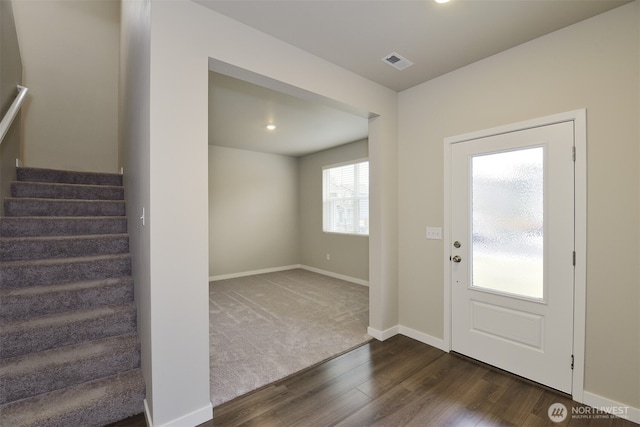 foyer with visible vents, baseboards, dark wood finished floors, and stairway