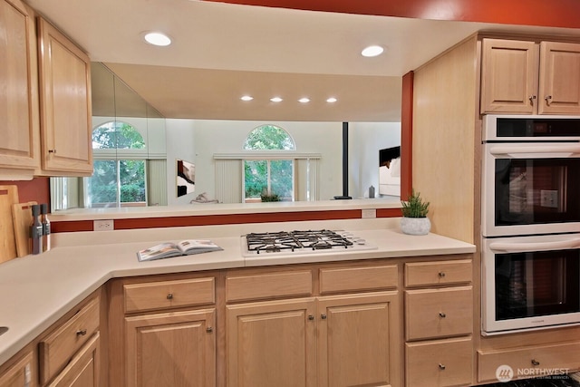 kitchen with white appliances, recessed lighting, light brown cabinets, and light countertops