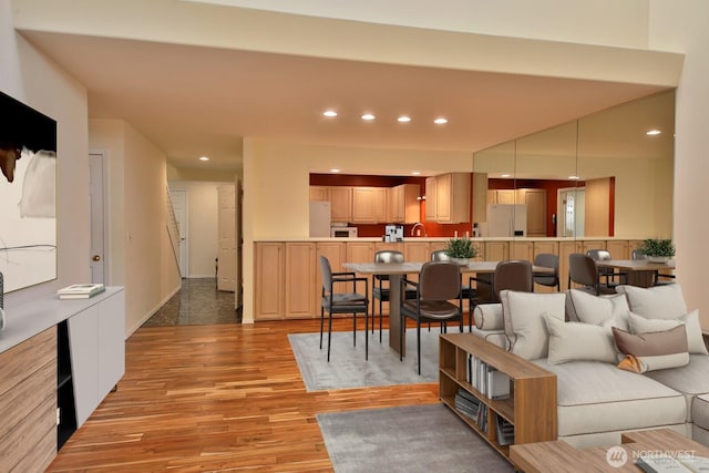 living room featuring recessed lighting, baseboards, and light wood-style floors