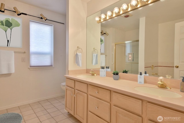 bathroom with tile patterned floors, a stall shower, double vanity, and a sink