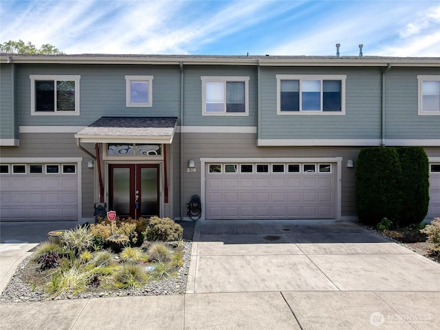 multi unit property featuring a garage and driveway