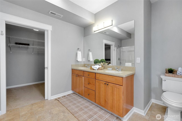 bathroom with visible vents, a shower stall, toilet, and a sink