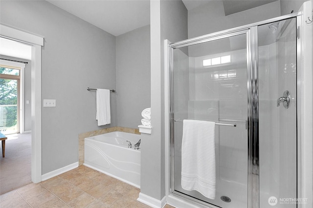 bathroom with baseboards, a garden tub, a shower stall, and tile patterned flooring