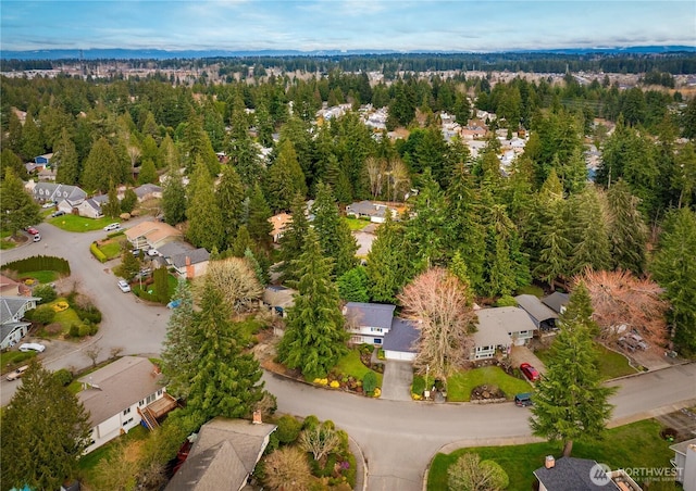 drone / aerial view featuring a residential view and a wooded view