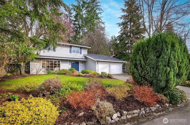 view of front of property featuring a front lawn, a garage, and driveway