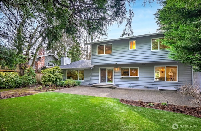 back of property featuring a patio, a lawn, a chimney, and entry steps