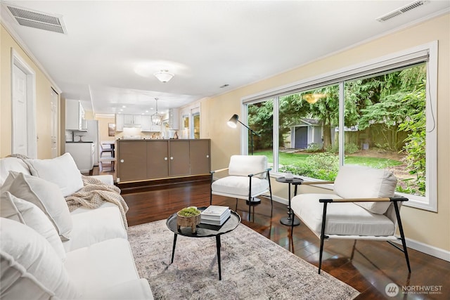 living area with dark wood-style floors, visible vents, and baseboards