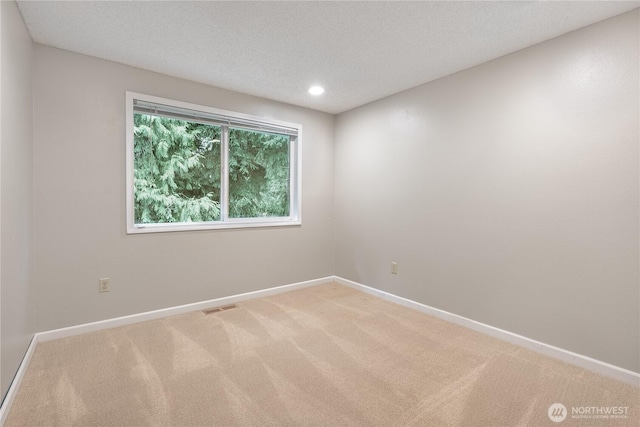 unfurnished room with visible vents, a textured ceiling, recessed lighting, baseboards, and light colored carpet